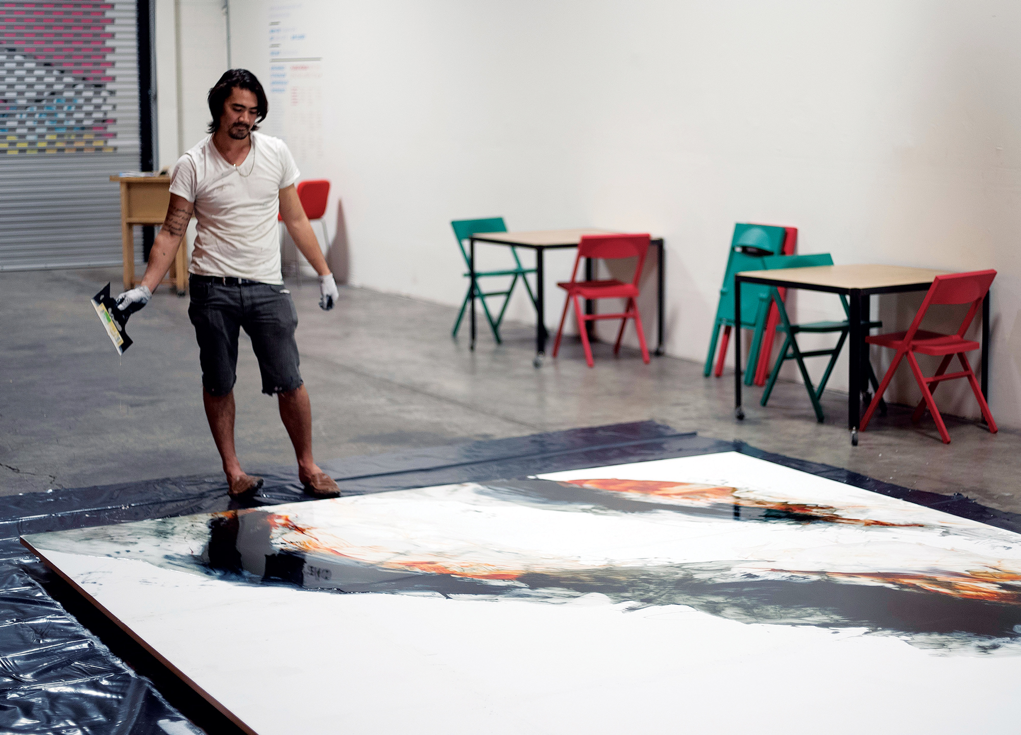 Matthew James ’00 at work on a large-scale painting created for a show in Kaka‘ako in 2015. It was recently installed at Waialua High School.