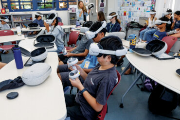 Class of seventh grade English students using Oculus VR headsets