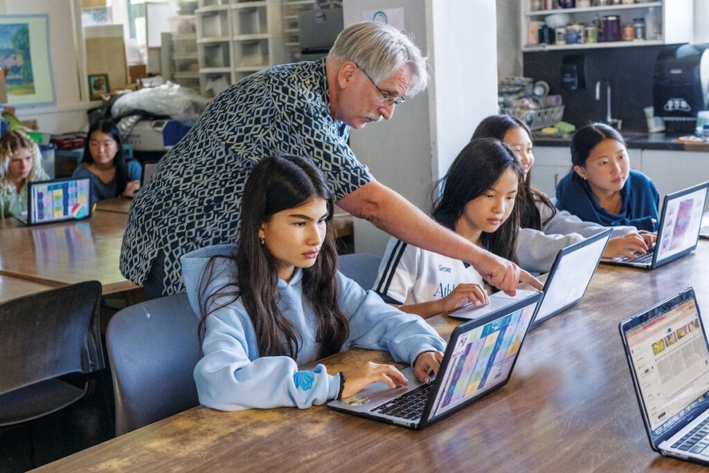 Students in an art class working on computers to create their AI book covers